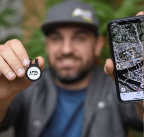 A field surveyor holding a Flic button beside a phone showing a map — the breadth of sectors we work with.