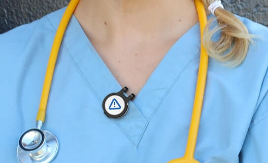 A nurse in pale-blue scrubs and stethoscope wearing a Flic safety button — the breadth of customer industries we serve.