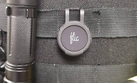A Flic Duo with a protective bumper, clipped to a tactical vest.