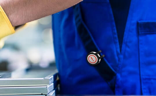 A WorkSafe Guardian field operator with a Flic button clipped to the chest strap.