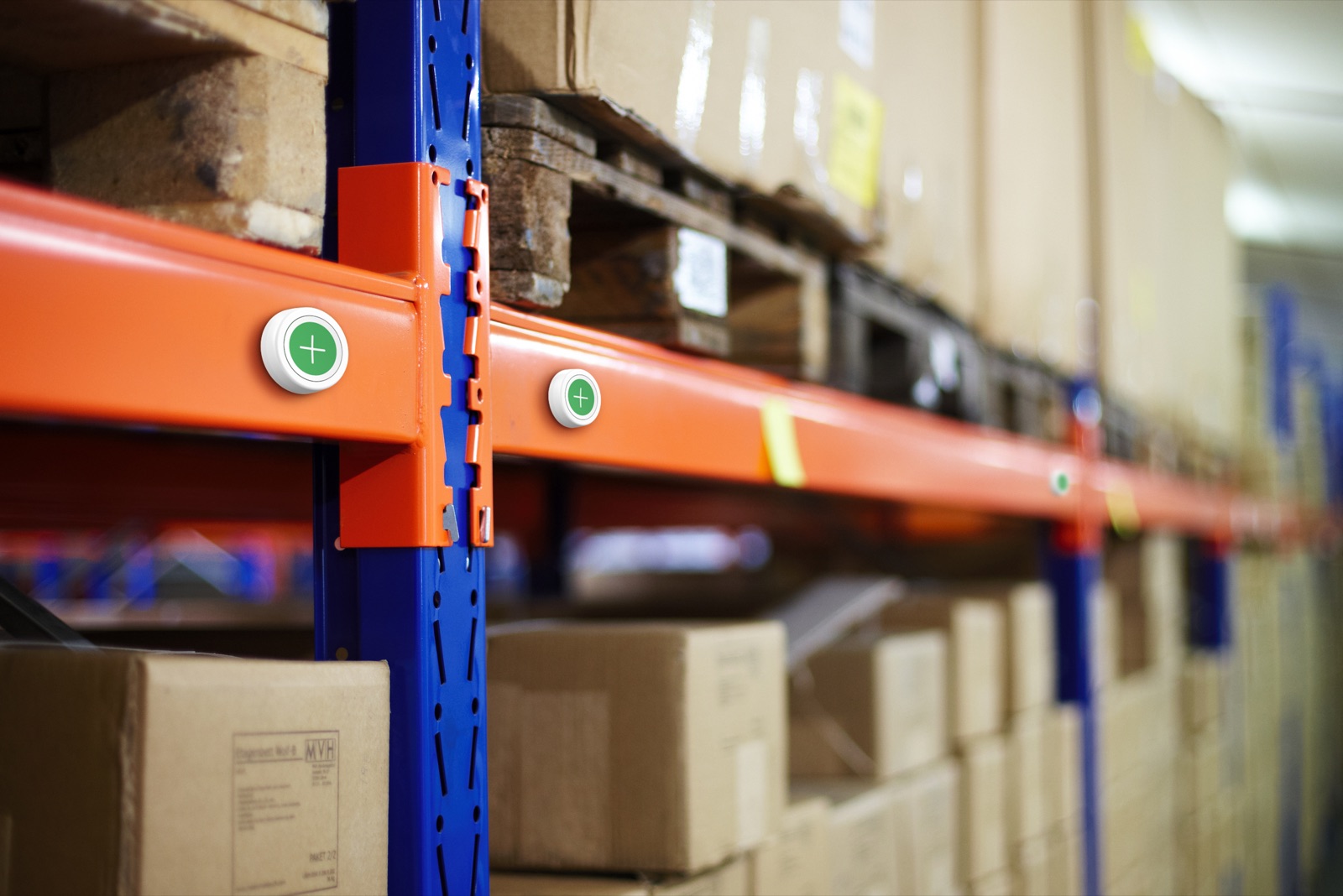 Two Flic Message Buttons mounted on orange industrial pallet racking in a busy logistics warehouse, ready for pick alerts and fault reports.